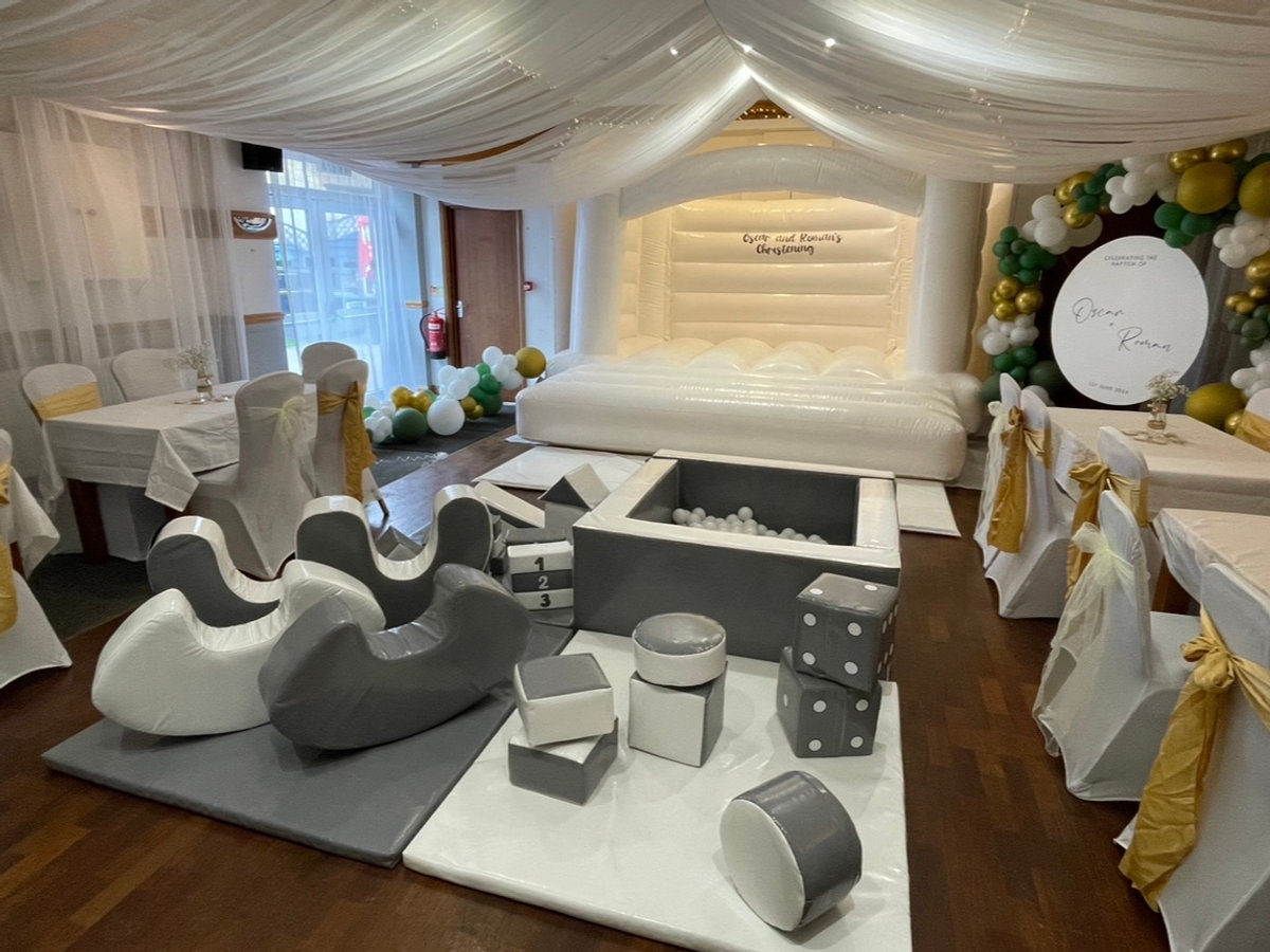 Function hall set up for a christening with buffet tables and drapes
